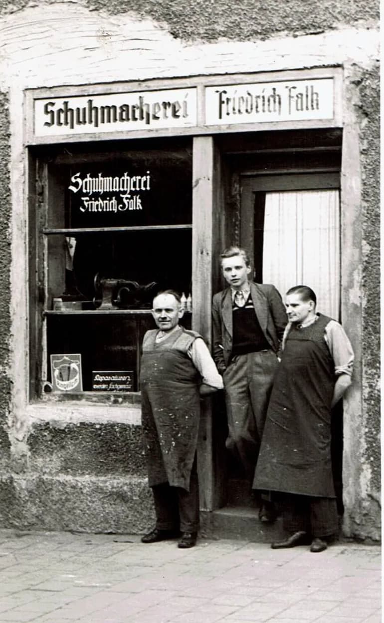 Schuhmacherei Friedrich Falk in der Maxfeldstraße 55, drei Schuhmacher vor dem Ladeneingang, um 1932